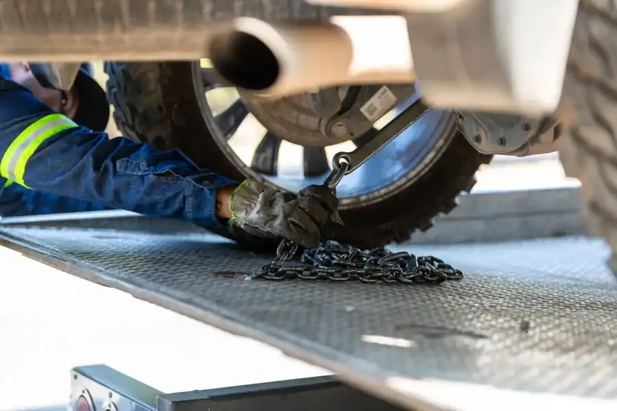 Fixarea autoturismului cu chingi peste roți, pe platformă